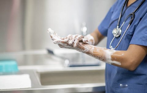 Medical Personnel Hand Washing Dressed in Medical Scrubs stock photo